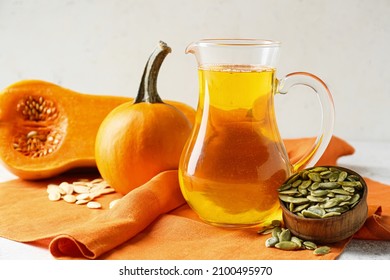 Jug With Pumpkin Seed Oil On Light Background