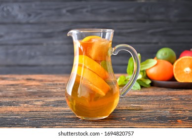 Jug of tasty cold tea on wooden table