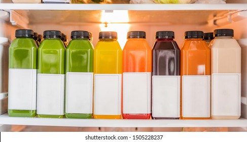 Juice bottles for detox cleanse juicing diet- Healthy food online delivery at home in fridge. Selection of many cold pressed vegetables and fruits juices, orange, lemon, beets, spinach, almond milk.