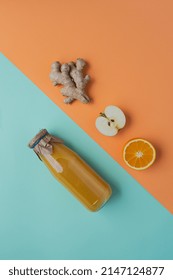 Juice Of Ginger, Orange And Apple On Green And Orange Backdrop, Overhead