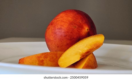 juice peach, peach slices on white plate, close up, gray background - Powered by Shutterstock