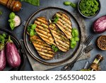 Juicy baked eggplants. Grilled vegetables. On a gray concrete background.