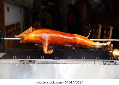 Juicy Crispy Whole Milk Pig Roasted On A Spit On Charcoal. Asian Cuisine.