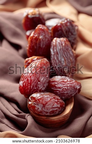 Juicy dates on the table with beige and brown satin.