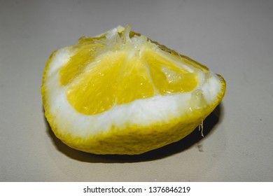 juicy fresh piece of lemon on a light surface. juicy piece of spring and summer
