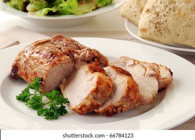 A Juicy Fresh Pork Loin Roast Sliced On A Plate