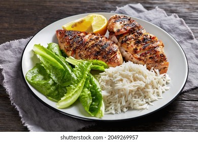 Juicy Grilled Chicken Breasts With Fresh Romaine Lettuce Leaves And Rice On A Plate On A Dark Wooden Table