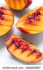 Juicy Grilled Nectarine Quarters On Light Gray Cutting Board.