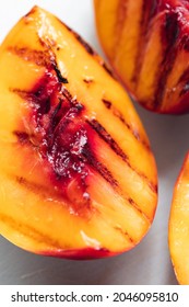 Juicy Grilled Nectarine Quarters On Light Gray Cutting Board.