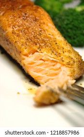 Juicy Grilled Wild-caught Salmon Seasoned With Creole Seasoning And Steamed Broccoli In The Background