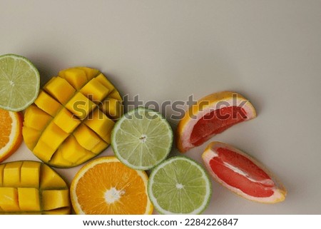 juicy healthy fresh fruit blend of citrus, orange, lime, grapefruit and tropical mango on a light beige background. for screensavers postcards covers signs inscriptions banners and much more
