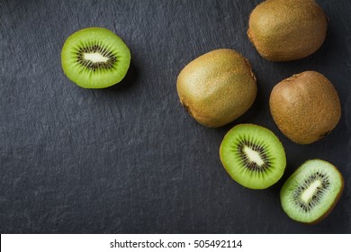 Juicy Kiwi Fruit On A Black Background, Top View, Copy Space