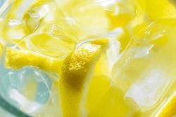 Juicy Lemon Slices With Ice And Water In A Very Cold Pitcher On A Yellow Colored Background, Selective Focus. Lemonade With A Lot Of Lemon And Ice Top View