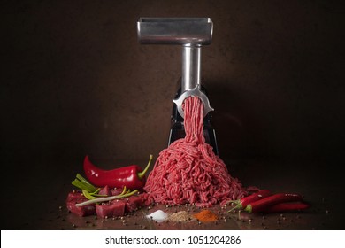 Juicy meat climbs out of the meat grinder. Minced meat and vegetables with spices.