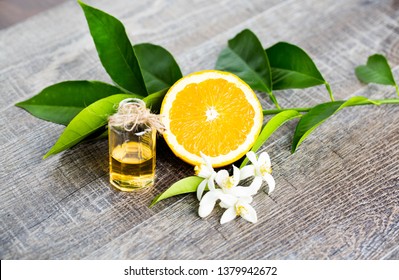 Juicy Orange Cut In Two Parts And Neroli, Flowers Of Orange Tree, On Rustic Wood Background. The Orange Blossom Is The Fragrant Flower Of The Citrus Is Used In Perfume And Tea, Aphrodisiac.