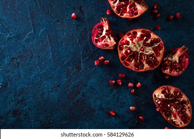 Juicy Pomegranates On Dark Blue Table.healthy Food Concept