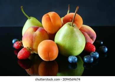 Juicy red ripe pears, plums, apricot, strawberries, blueberries, peach fruits on black background, closeup