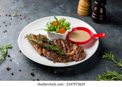 Juicy Ribeye Steak With Pepper Sauce On White Plate