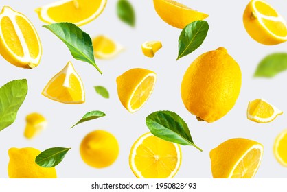 Juicy ripe flying yellow lemons, green leaves on light gray background. Creative food concept. Tropical organic fruit citrus vitamin C. Lemon slices Summer minimalistic bright fruit background Pattern - Shutterstock ID 1950828493