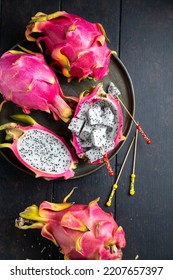 Juicy Ripe Pink Dragon Fruit, Pitaya. Whole And Cut Fruits On A Dark Wooden Background. Raw Food, Fruit Plate