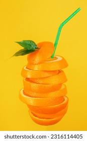 Juicy slices of orange are cut in the form of a cocktail with a straw on a yellow background. Refreshing orange juice drink. Design idea for advertising a fruit drink. - Shutterstock ID 2316114405