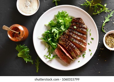 Juicy Steak Medium Rare Beef With Green Salad On White Plate Over Black Stone Table. Top View, Flat Lay