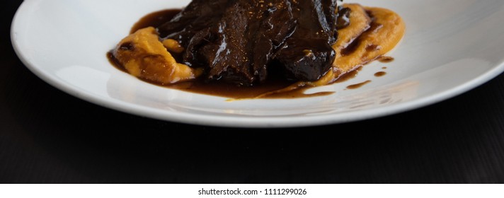 Juicy Stewed Beef In Red Wine Sauce Served With Sweet Potato Puree.