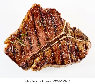 Juicy Thick Grilled T-bone Beef Steak Seasoned With Rosemary Fresh Of The Summer BBQ Viewed From Above In A Close Up View Over White