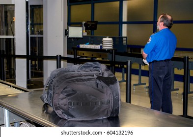 July 14, 2014, USA; A TSA Worker Stands By While An Unattended Bag Waits To Be Claimed At An America  Airport