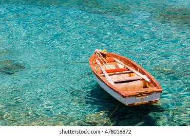JULY 2016: Traditional wooden fishing boat floating on the colourful waters in the afternoon against the blue waters, Lakonia, Greece
