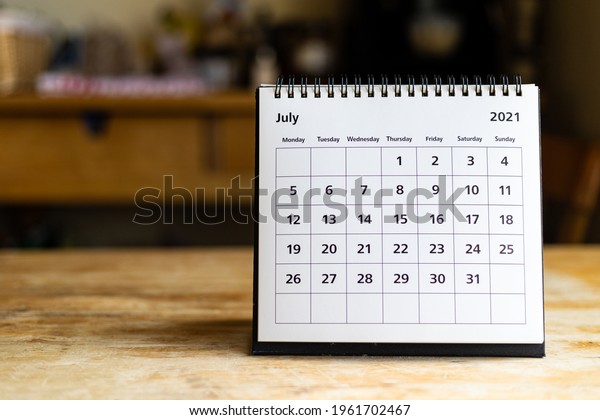 July 2021 calendar - month page showing date on\
wooden table