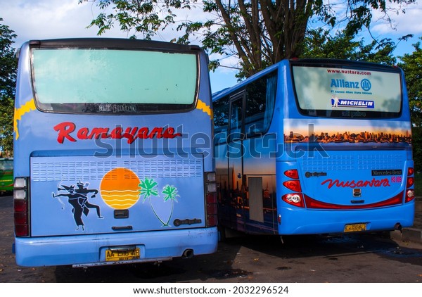 July 22,\
2010 at the Jombor bus terminal in Yogyakarta.  The 2 buses\
photographed from the back have the same color and the company name\
is written in red, although they are\
different.