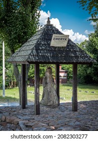 July 30, 2021 - Nowa Slupia, Poland:
A stone figure of a legendary pilgrim Emeryk, kneeling under the wooden roof, at the foot of the Holy Cross Mountain. No people, summer day. 
