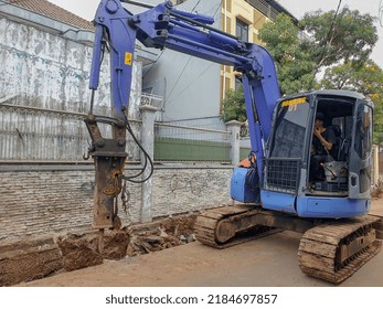 July 31 2022, 11.31 Am, DKI Jakarta, Indonesia, A Heavy Equipment With A Driver Inside, Is Carrying Out Demolition Of The Road For The Construction Of City Waterways