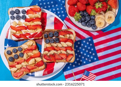  July 4 breakfast sandwiches, holiday snack or brunch with peanut butter, chocolate and cheese spread, with strawberries, blueberries and banana in the shape of america patriotic flag - Powered by Shutterstock