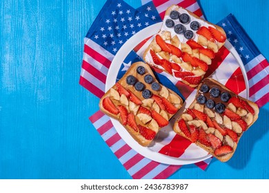  July 4 breakfast sandwiches, holiday snack or brunch with peanut butter, chocolate and cheese spread, with strawberries, blueberries and banana in the shape of america patriotic flag - Powered by Shutterstock