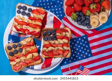  July 4 breakfast sandwiches, holiday snack or brunch with peanut butter, chocolate and cheese spread, with strawberries, blueberries and banana in the shape of america patriotic flag - Powered by Shutterstock