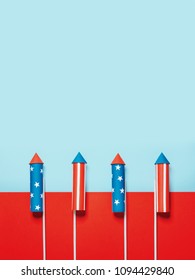 July 4, rockets for fireworks on a blue red background with space for text. in the style of minimalism - Shutterstock ID 1094429840