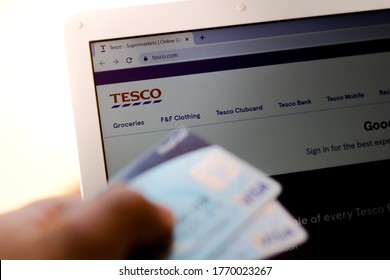 July 5, 20020, Brazil. The Tesco website is shown on a laptop in the background and a person holds a bank card