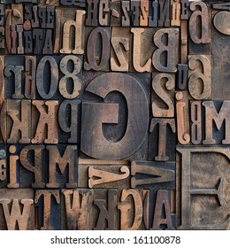 Jumbled Arrangement Of Different Sized Wooden Printers Typeface Letters Of The Alphabet Forming A Background Pattern