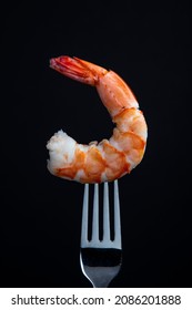 Jumbo Cooked Shrimp On A Fork Isolated On Black Background.