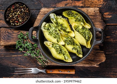 Jumbo shells italian pasta Conchiglioni konkiloni stuffed with beef meat and spinach. Dark Wooden background. Top view