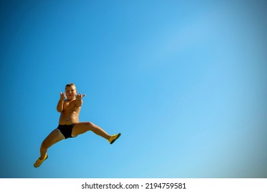 Jump Into The Water. A Boy Caught Jumping Into The Water. Caught In The Moment Of Flight