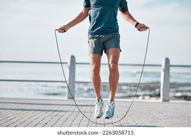 Jump rope, fitness and man by a sea promenade with training, sports and exercise equipment. Health, jumping and body wellness of a athlete doing cardio jump for active lifestyle by the ocean - Powered by Shutterstock