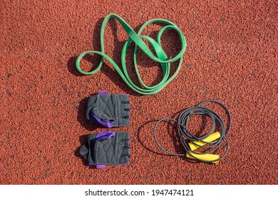 Jump Rope, Sports Gloves And A Tourniquet For Sports Training On The Background Of A Treadmill.