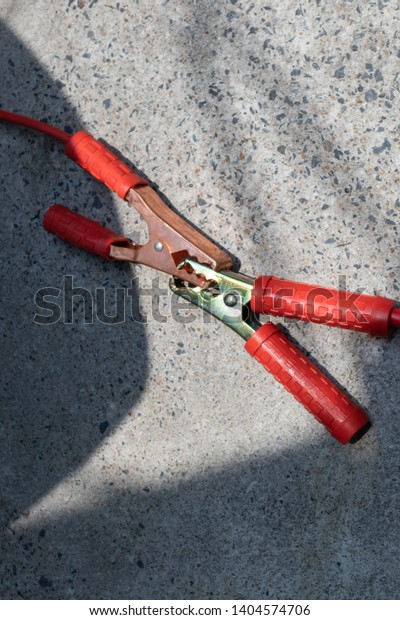 Jumper cables connect to another jumper cables\
for longer cables on cement\
ground.
