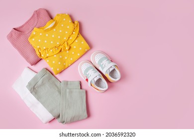 Jumpers  And Pants With Sneakers. Set Of Baby Clothes And Accessories For Spring, Autumn Or Summer On  Pink Background. Fashion Kids Outfit. Flat Lay, Top View