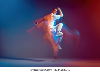 Jumping cool young girl with short hair dance modern hip-hop, breakdance in neon colourful light. Long exposure - Shutterstock ID 2134285141