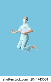 Jumping female doctor on color background