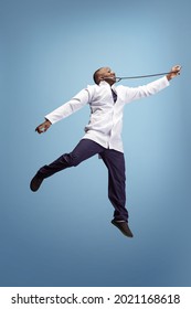 Jumping, Flying. One Funny Doctor, Therapeutic Or Medical Advisor Posing Isolated On Blue Studio Back Ground. Funny Meme Emotions. Concept Of Healthcare, Care, Medicine And Humor. Copy Space For Ad